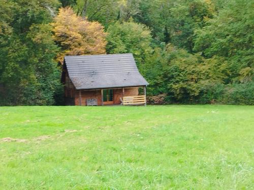 een kleine blokhut in een grasveld bij Gîte Chalet Morvan Bourgogne in Corancy