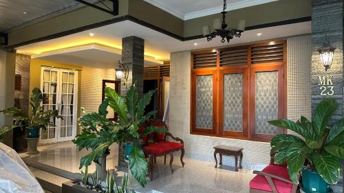 a living room with plants and a red chair at The Heritage Kraton Guest House in Timuran