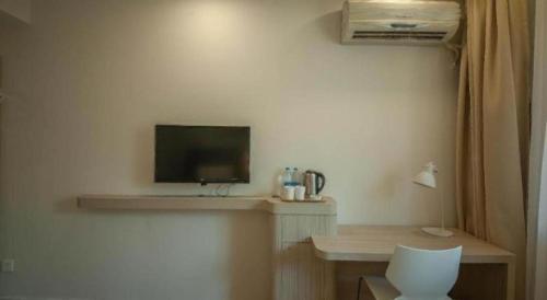 a room with a desk with a tv and a chair at 7 Days Inn Suzhou Wangting Pearl Commercial Plaza in Suzhou