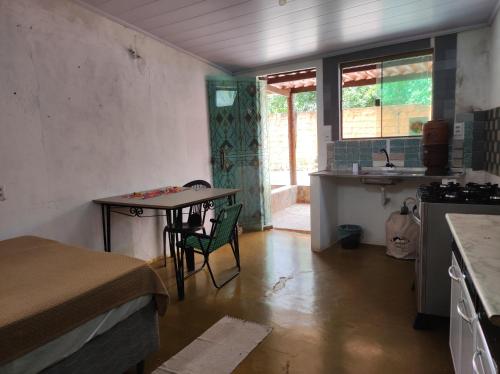 a small kitchen with a table and a sink at lobeira in Alto Paraíso de Goiás