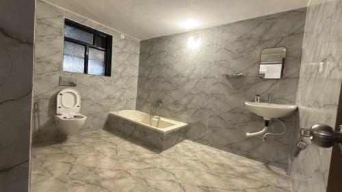 een badkamer met een wastafel, een bad en een toilet bij Mavika Stay in Navi Mumbai