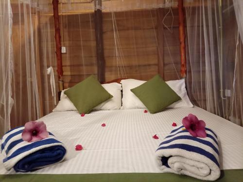 a bed with two towels and flowers on it at Echo retreat in Tangalle