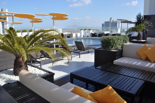 un toit-terrasse avec des tables et des chaises ainsi qu'une piscine dans l'établissement Novotel Tunis, à Tunis