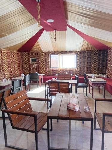 een eetkamer met houten tafels en stoelen bij Mars Camp, Lunar Space in Wadi Rum