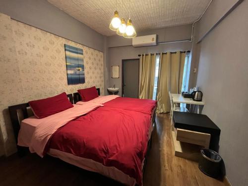 - une chambre avec un lit rouge et un bureau dans l'établissement Neels&Bill's Apartment, à Bangkok