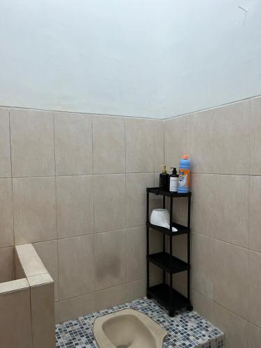 a bathroom with a toilet in a tiled wall at Raphi house in Yogyakarta