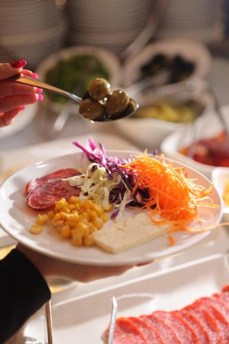 een bord met eten met vlees en groenten op een tafel bij Park Resort Aghveran in Agveran
