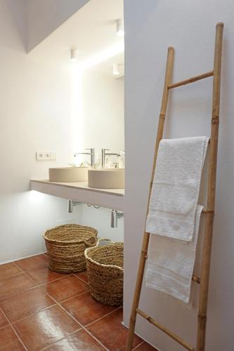 a towel ladder in a bathroom with a sink at Villa Cala Xuclar in Portinatx