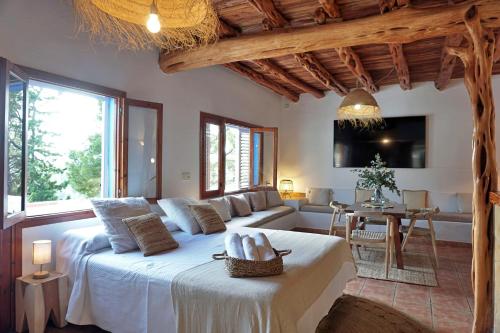 een slaapkamer met een groot bed en een woonkamer bij Villa Cala Xuclar in Portinatx