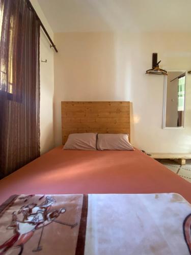 ein Schlafzimmer mit einem Bett mit einer orangefarbenen Tagesdecke in der Unterkunft Villa Éden in Dakar