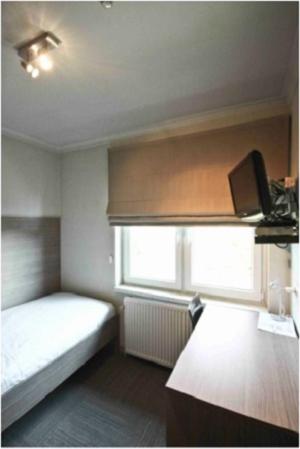 Habitación pequeña con cama y ventana en Hotel de modern, en Diest