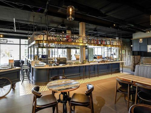 兰茨胡特ibis Landshut City的带酒吧的餐厅，配有桌椅