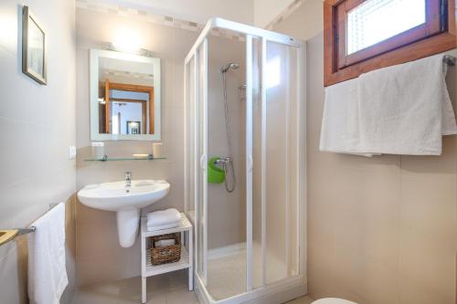 une salle de bain avec douche et lavabo dans l'établissement Chalet Addaya, à Port d'Addaia