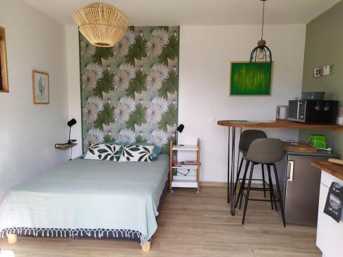 een kleine slaapkamer met een bed en een keuken bij Studio terrasse au calme près de Narbonne in Narbonne