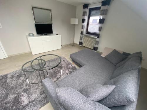 ein Wohnzimmer mit einer grauen Couch und einem Tisch in der Unterkunft 2 Zimmer-Wohnung ruhig modern zentrumsnah in Abensberg