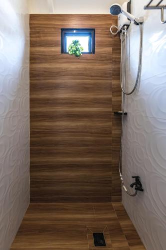 a shower with a wooden door in a bathroom at Tagaytay Staycation with Pool and Free Private Parking in Tagaytay