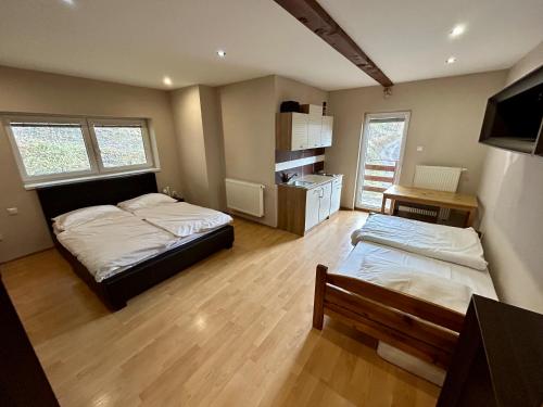 een slaapkamer met 2 bedden en een keuken. bij Chata pod lesom in Drienica