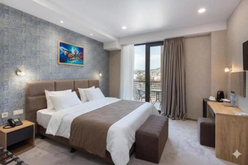 a bedroom with a large bed and a balcony at Brooch Boutique Hotel in Tbilisi City