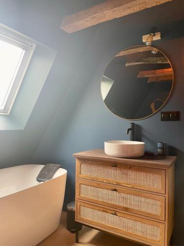 een badkamer met een wastafel en een spiegel op een dressoir bij Maison in Le Bugue