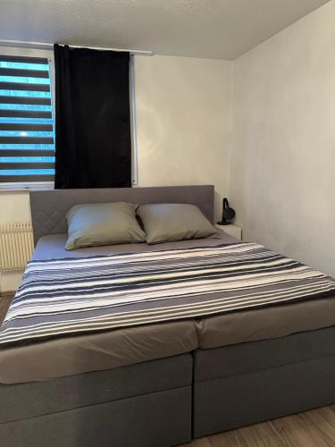 een groot bed in een slaapkamer met een raam bij Jonas Haus Gästezimmer in Berlijn