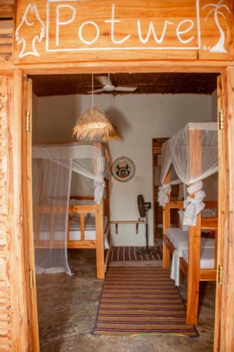 a room with two bunk beds in a house at Coconut Mafia Island Bungalows in Utende