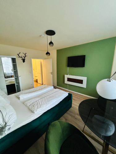 ein Schlafzimmer mit einem großen Bett mit einer grünen Wand in der Unterkunft Elegant Studio in Gengenbach Old Town with Tower View in Gengenbach