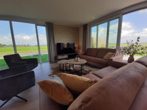 a living room with a couch and chairs and a tv at Spacious holiday home in Leons with garden in Leons