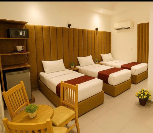 Valencia hotel Downtown في القاهرة: غرفة فندق بها سريران وطاولة