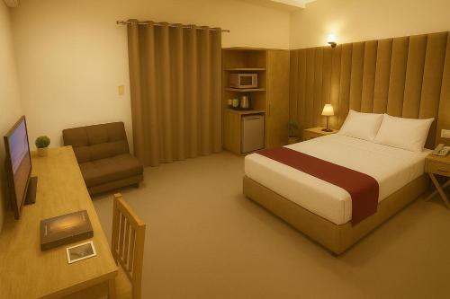 Valencia hotel Downtown في القاهرة: غرفة نوم بها سرير ومكتب وتلفزيون