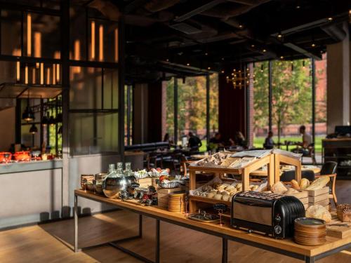 a bakery with a table filled with bread and other items at The Bridge Wroclaw - MGallery in Wrocław