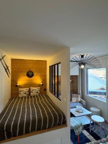 a bedroom with a bed and a living room at Charming studio with balcony in Samoëns