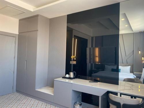 a bedroom with a bed and a desk with a mirror at Görükle Güler Park Hotel in Gorukle