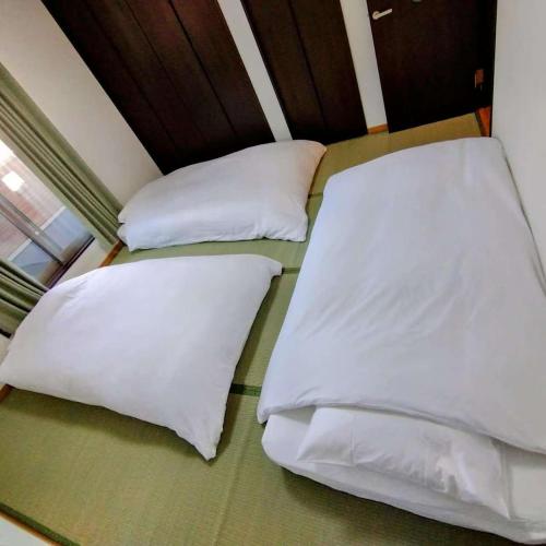 two beds in a room with white pillows at 京旅别莊 in Kyoto
