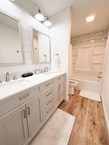 a bathroom with a sink and a toilet and a mirror at Lakefront 4BDBunkRm-25BA-DockFirepitSlide-14 in Sunrise Beach