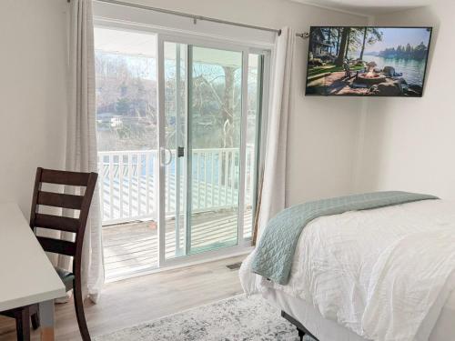 a bedroom with a bed and a sliding glass door at Lakefront 4BDBunkRm-25BA-DockFirepitSlide-14 in Sunrise Beach