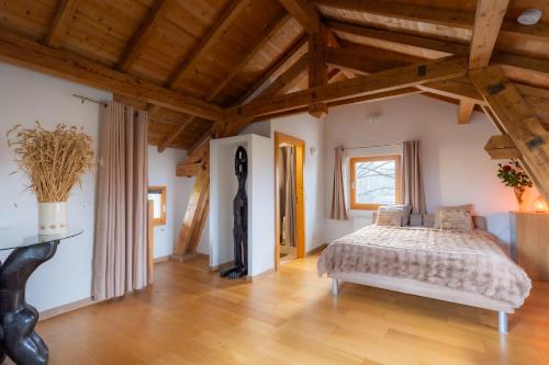 a bedroom with a bed and a wooden ceiling at Séjour paisible près de Genève in Neydens