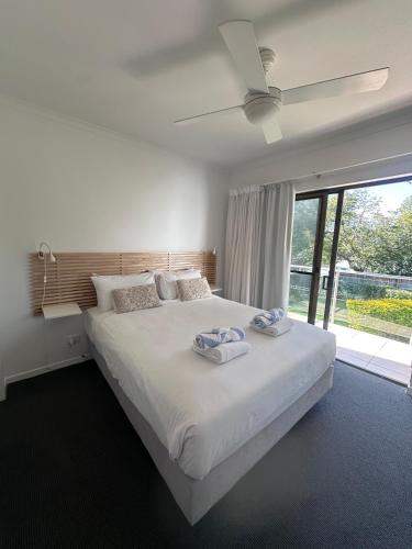 a bedroom with a large bed with two towels on it at Endless Summer 2BR Apartment with Private Beach in Noosa Heads
