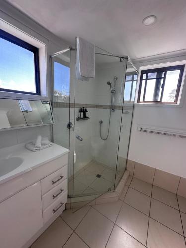 a bathroom with a shower and a sink at Endless Summer 2BR Apartment with Private Beach in Noosa Heads