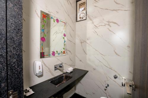 ein Badezimmer mit Waschbecken und Spiegel in der Unterkunft Namaste Khatu Shyam in Khātu