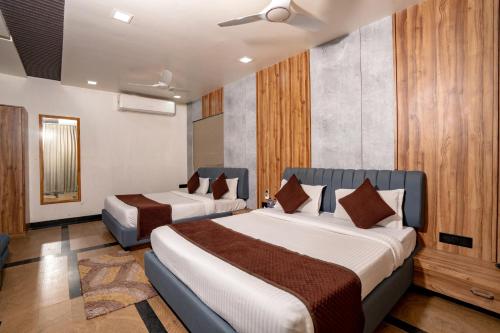 ein Hotelzimmer mit zwei Betten in einem Zimmer in der Unterkunft Namaste Khatu Shyam in Khātu