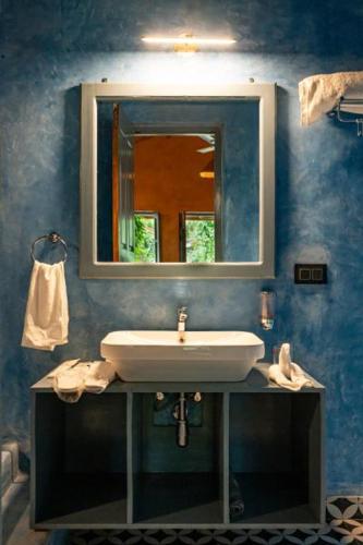 a bathroom with a sink and a mirror at Aqua Bella Resort in Mandrem