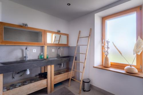 a bathroom with a sink and a window at Séjour paisible près de Genève in Neydens