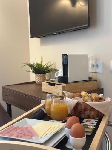 a breakfast tray with eggs and juice on a table at Maissance in Preveza