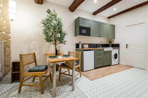 een keuken met groene kasten en een tafel en stoelen bij Antibes Old Town Apartment in Antibes