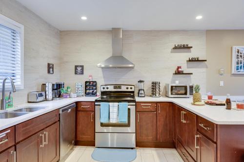 een keuken met houten kasten en een kookplaat met oven bij Pocono Paradise Ultimate Camelback Getaway townhouse in Crescent Lake