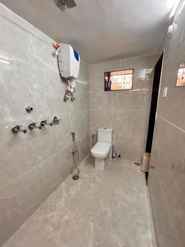 a bathroom with a white toilet and a shower at Narpati Villa in Jodhpur