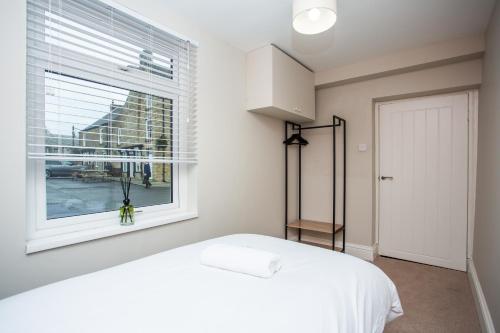 a bedroom with a white bed and a window at Vacant Nests The Allendale Central 3BR in Allendale Town