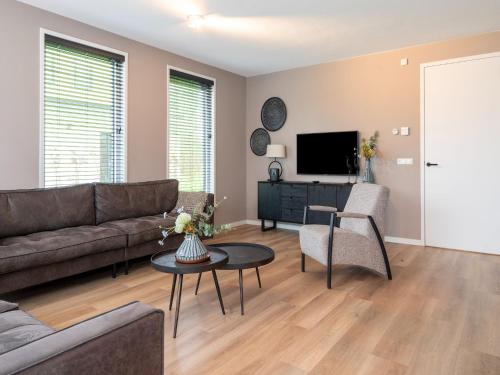 a living room with a couch and a tv at Serene Holiday Home in De Koog Texel with Sauna in Westermient