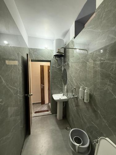 a bathroom with a sink and a toilet at Rivana Retreat in Dehradun