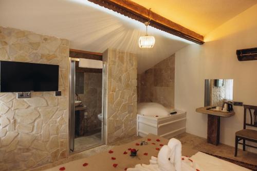 een slaapkamer met een douche en een tv in een kamer bij Hatun Konağı in Eskiömerler